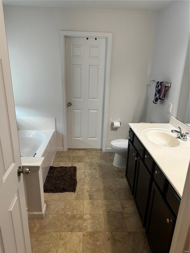 bathroom featuring a bathing tub, vanity, and toilet