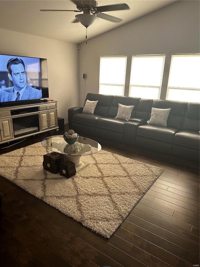 living room featuring ceiling fan, dark hardwood / wood-style flooring, and vaulted ceiling