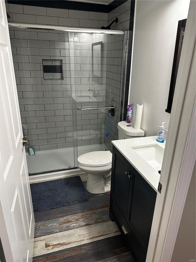 bathroom with vanity, hardwood / wood-style flooring, toilet, and walk in shower