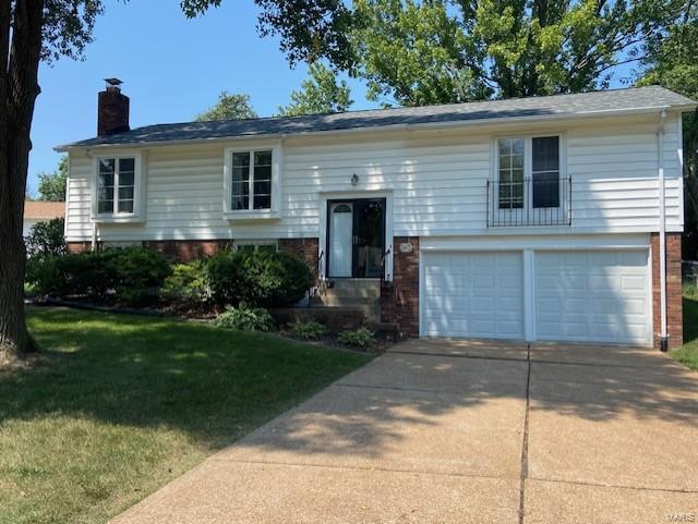 split foyer home featuring a garage and a front yard