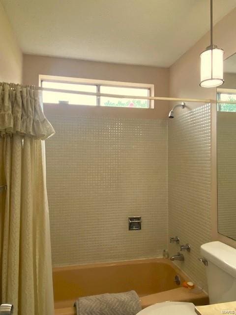 bathroom with toilet, shower / tub combo, and plenty of natural light