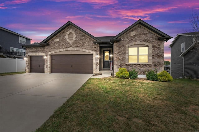 view of front of property featuring a lawn and a garage