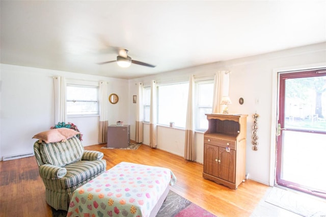 living room with light wood-type flooring, plenty of natural light, and ceiling fan