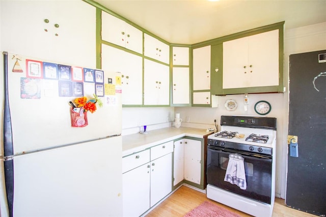 kitchen with white cabinets, light wood-type flooring, and white appliances