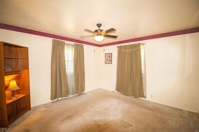 spare room with ceiling fan and light carpet