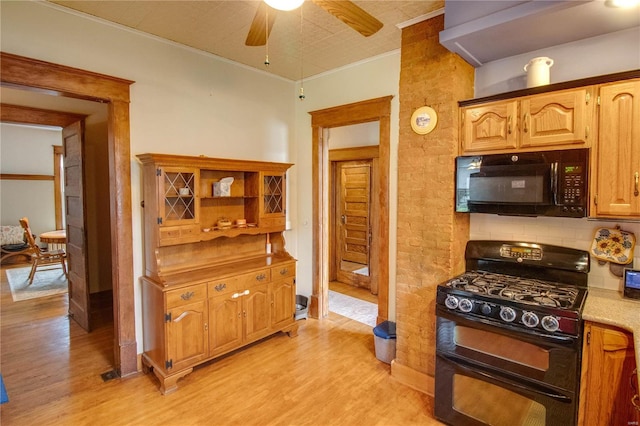 kitchen with light hardwood / wood-style floors, black appliances, ornamental molding, and ceiling fan