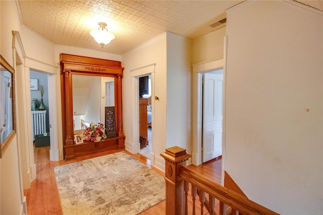 entrance foyer featuring crown molding and light wood-type flooring