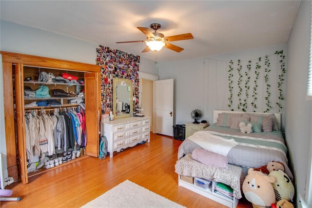 bedroom featuring radiator heating unit, a closet, hardwood / wood-style flooring, and ceiling fan