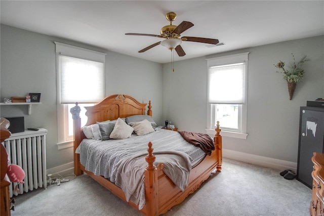 carpeted bedroom with ceiling fan and radiator