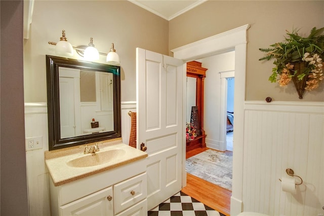 bathroom with wood-type flooring, crown molding, and vanity