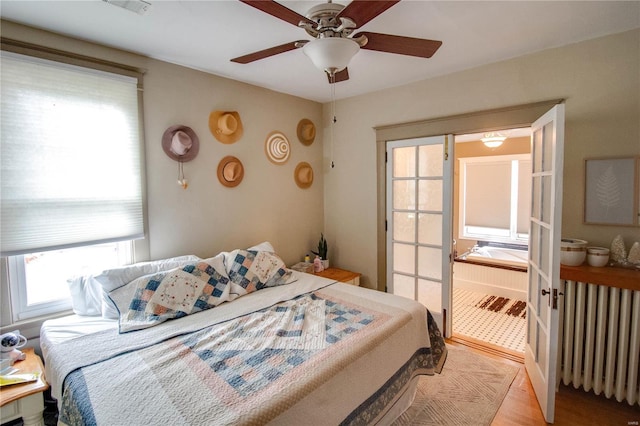 bedroom with radiator, light wood-type flooring, and ceiling fan