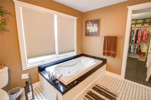 bathroom featuring tile patterned floors, toilet, and a bathtub