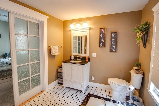 bathroom featuring tile patterned flooring, toilet, and vanity