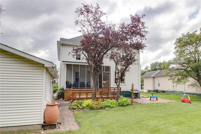 rear view of property featuring a patio and a lawn