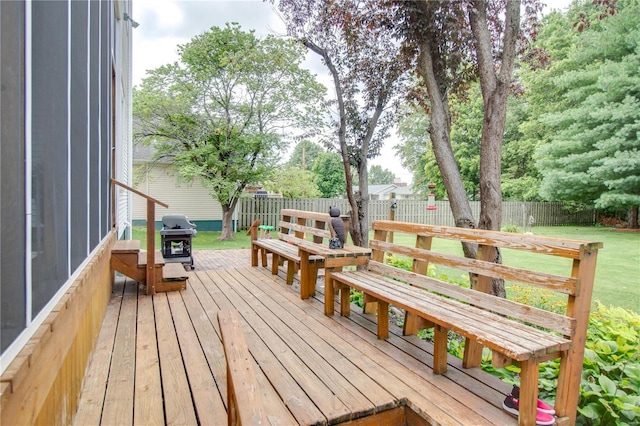 wooden deck with a yard and a grill