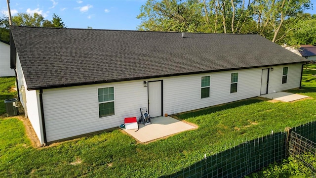 rear view of property featuring a patio, central AC unit, and a lawn