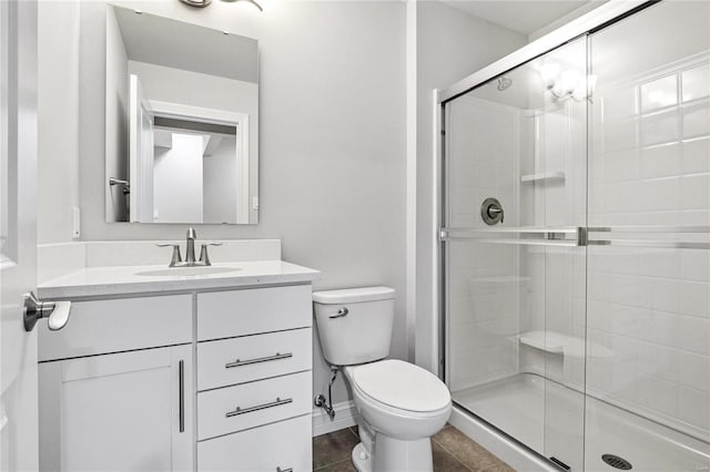 full bath featuring baseboards, toilet, tile patterned floors, vanity, and a shower stall