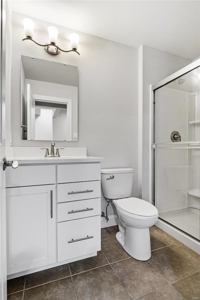 bathroom with toilet, tile patterned flooring, a shower stall, and vanity