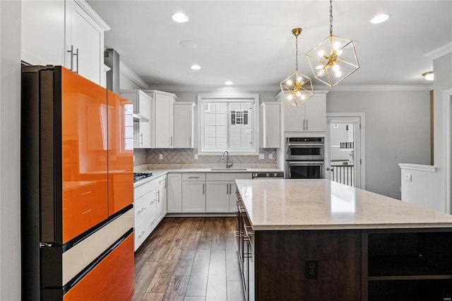 kitchen featuring hanging light fixtures, a center island, white cabinets, and freestanding refrigerator