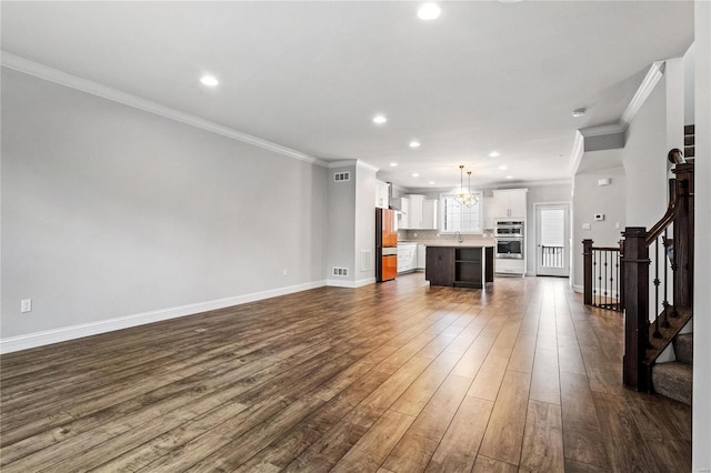 unfurnished living room featuring recessed lighting, dark wood-type flooring, baseboards, ornamental molding, and stairway