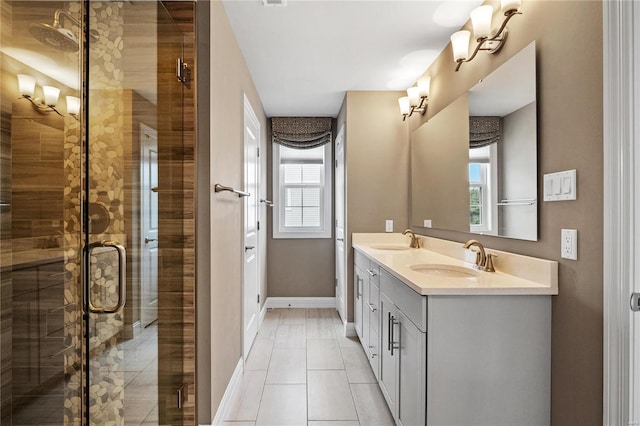 full bath featuring double vanity, a stall shower, a sink, and baseboards