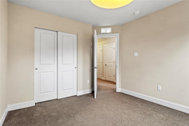 unfurnished bedroom featuring carpet floors, a closet, and baseboards