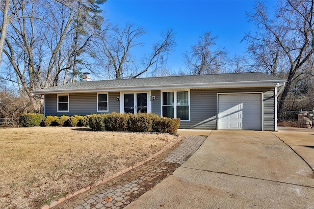 ranch-style home with an attached garage, a shingled roof, concrete driveway, and a front yard