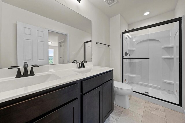 bathroom with double vanity, tile patterned floors, toilet, and an enclosed shower