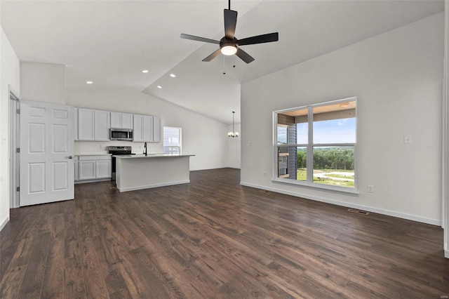 unfurnished living room featuring vaulted ceiling, dark hardwood / wood-style flooring, sink, and ceiling fan