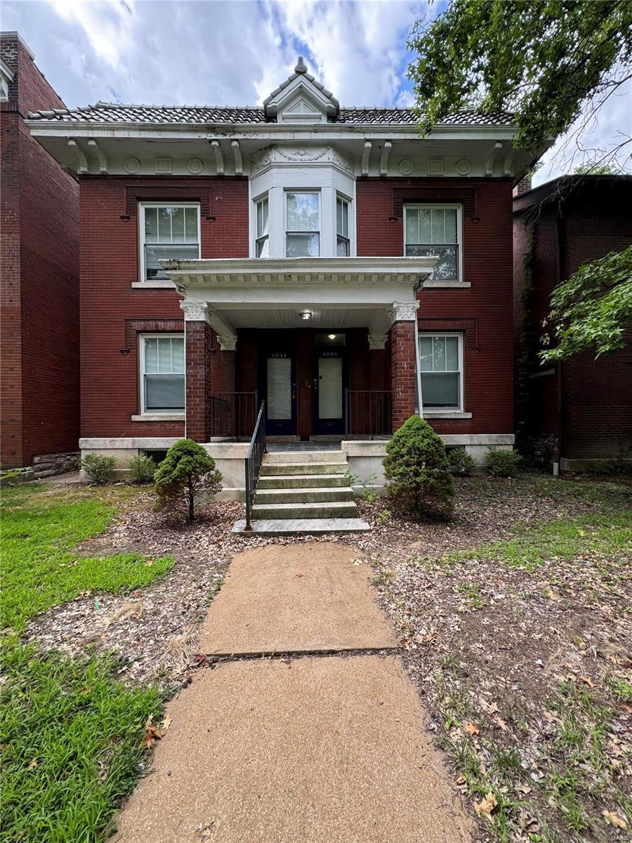 view of front of house featuring a tile roof and brick siding