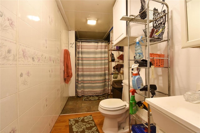 bathroom featuring toilet, vanity, hardwood / wood-style flooring, tile walls, and a shower with curtain