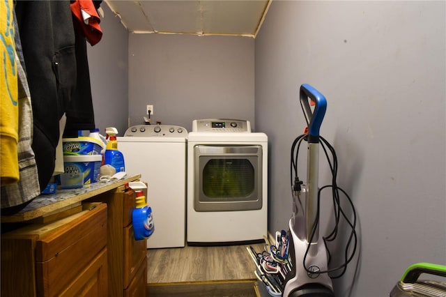 laundry room featuring wood-type flooring and washer and dryer