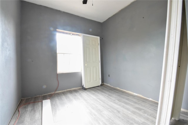 empty room with ceiling fan and light hardwood / wood-style floors