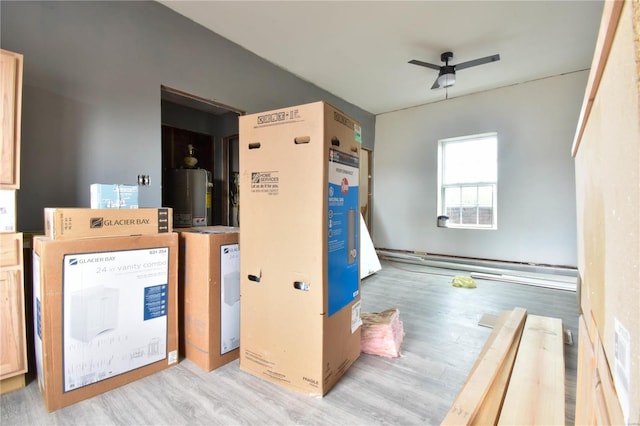 laundry area with gas water heater, ceiling fan, and light wood-type flooring