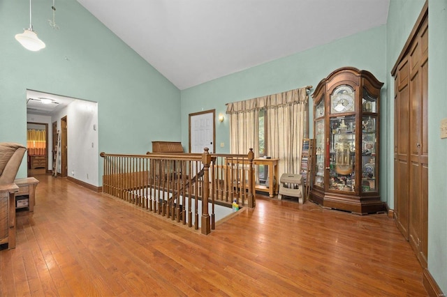 foyer entrance with high vaulted ceiling and wood-type flooring