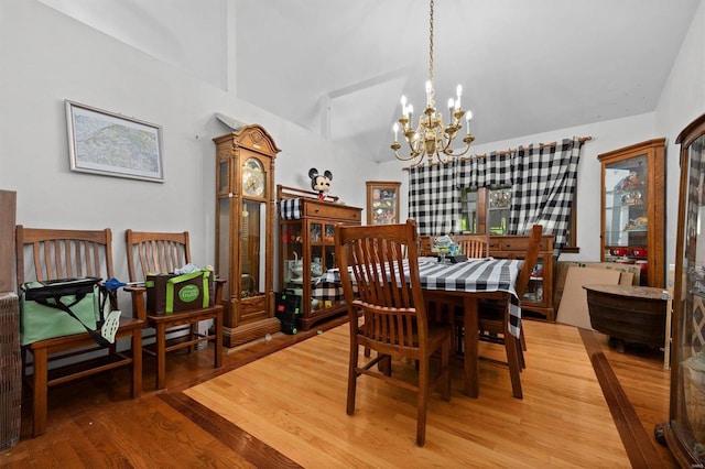 dining room with light wood-type flooring, lofted ceiling, and a chandelier