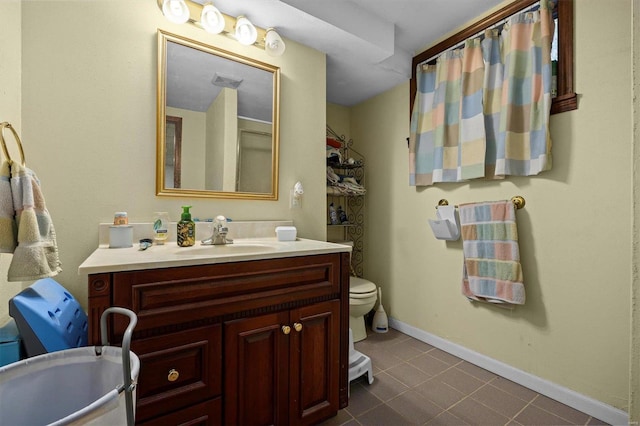 bathroom with tile patterned flooring, vanity, and toilet