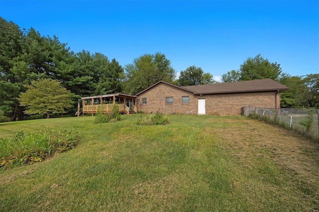 view of front of house with a deck and a front yard