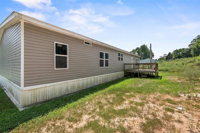 view of home's exterior with a deck and a lawn