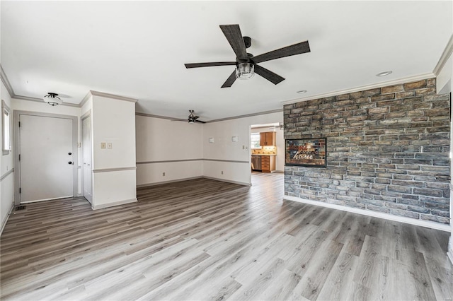 unfurnished living room with ornamental molding, ceiling fan, and light wood-type flooring