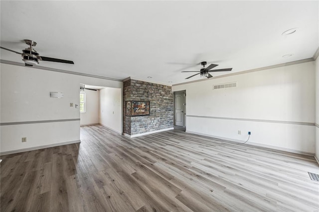 unfurnished living room with ornamental molding, a fireplace, ceiling fan, and light hardwood / wood-style flooring