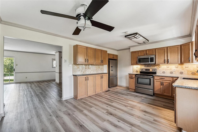 kitchen featuring sink, decorative backsplash, stainless steel appliances, crown molding, and light hardwood / wood-style flooring