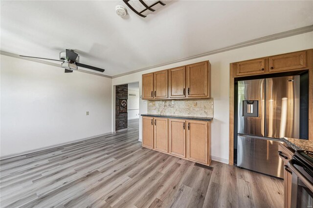 kitchen featuring crown molding, stainless steel fridge, light hardwood / wood-style flooring, and ceiling fan