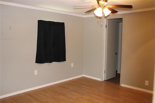 spare room featuring crown molding, hardwood / wood-style flooring, electric panel, and ceiling fan