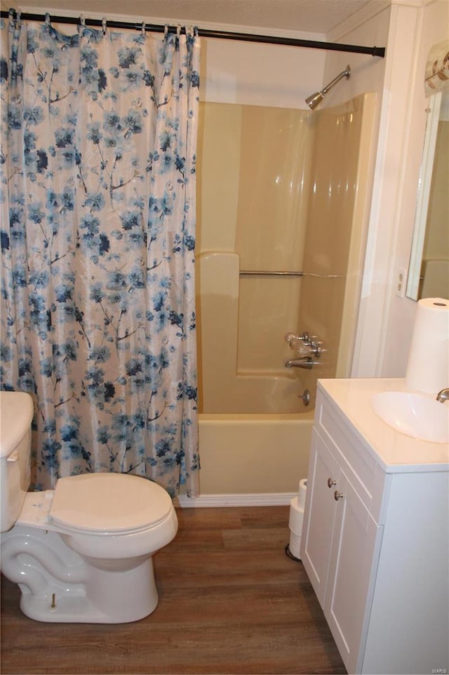 full bathroom featuring vanity, hardwood / wood-style floors, shower / bath combo, and toilet