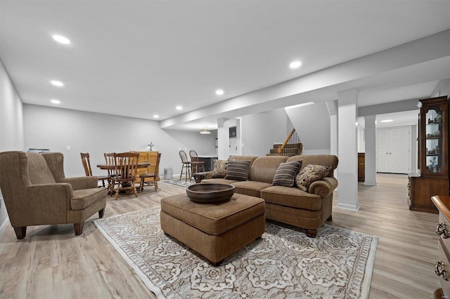 living room featuring light wood-type flooring, stairway, baseboards, and recessed lighting