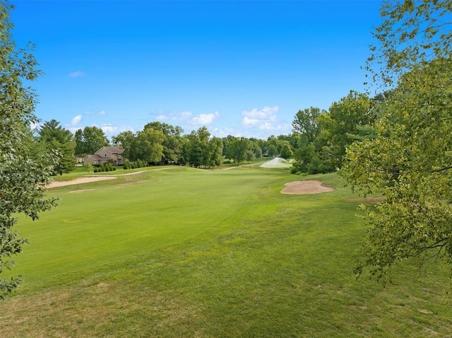 view of home's community with view of golf course and a lawn