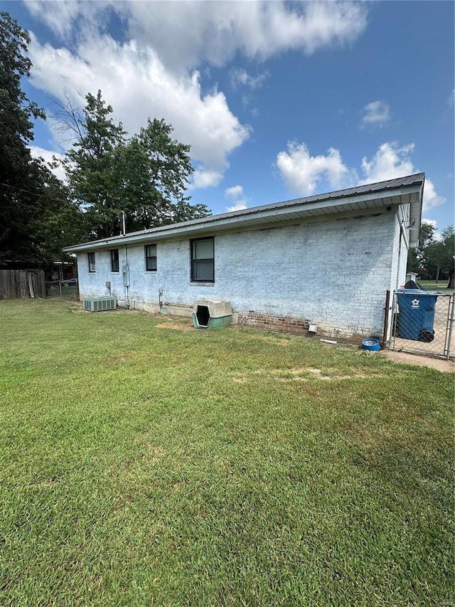 rear view of house with a yard and central air condition unit