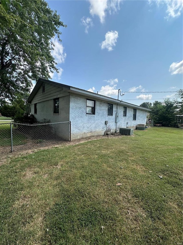 rear view of house featuring a yard and central AC