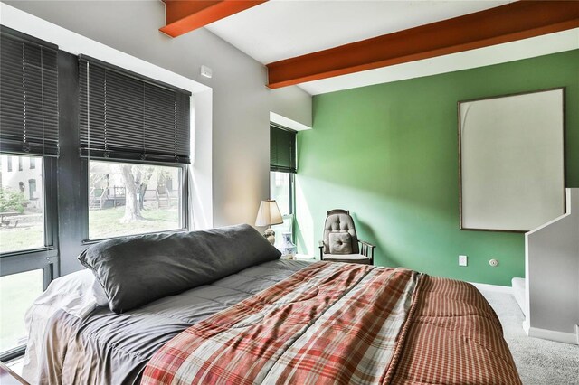 carpeted bedroom featuring beam ceiling